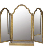 Tri-fold vanity mirror with gold frame on a white background