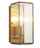 Wall-mounted light fixture with glass cover and gold frame on a white background