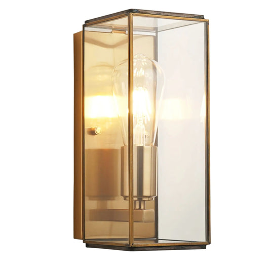 Wall-mounted light fixture with glass cover and gold frame on a white background