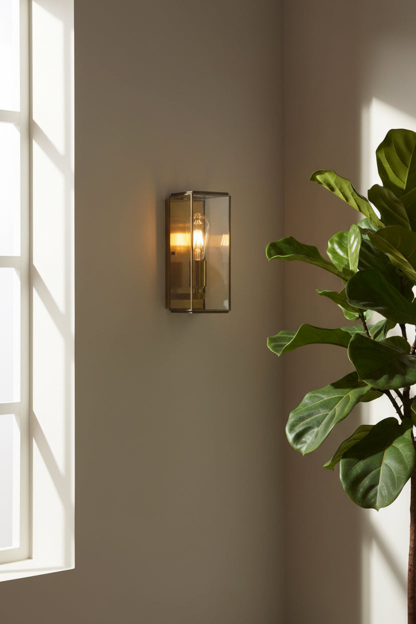 Wall-mounted light fixture with glass enclosure on a white wall