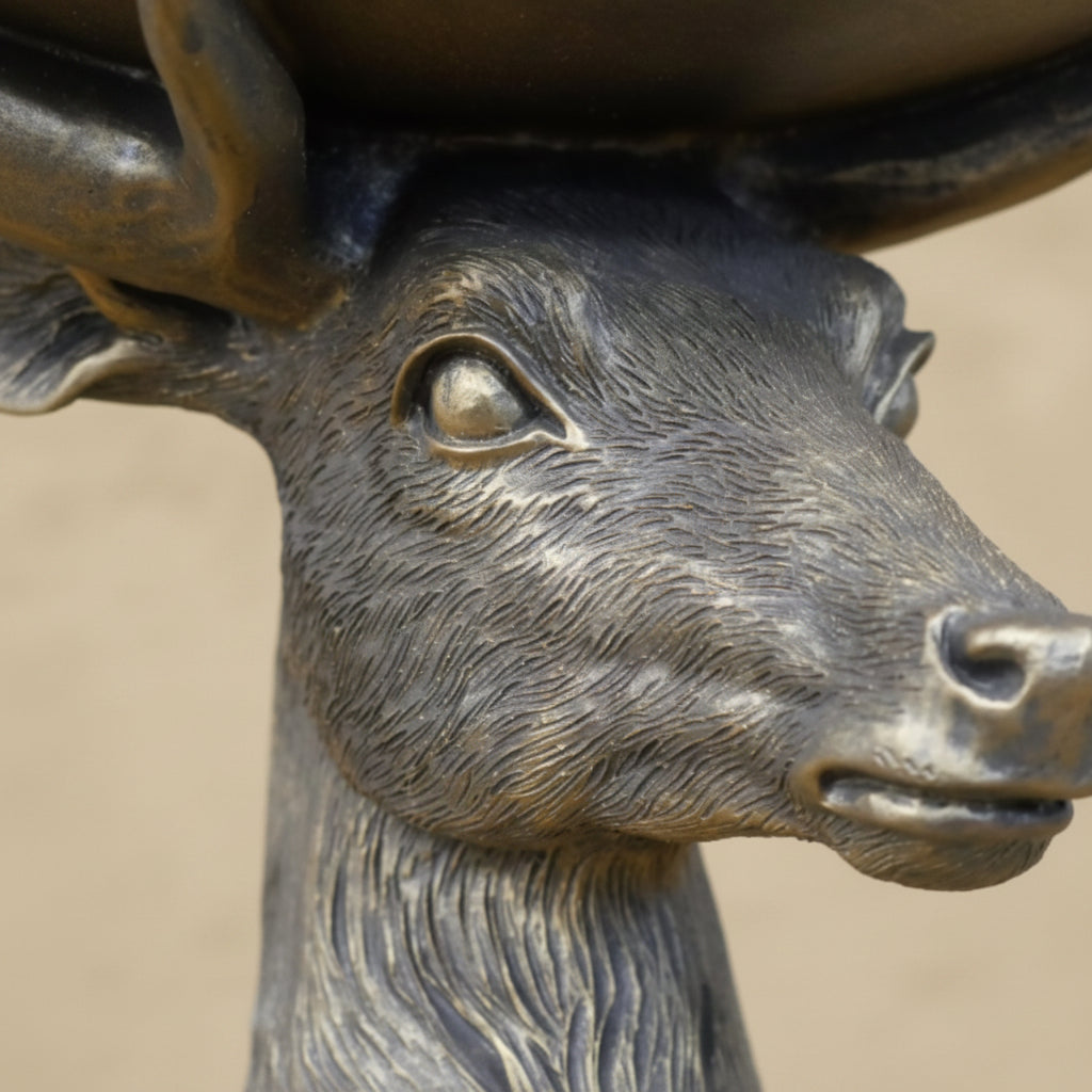 Bronze statue of a deer head with blurred background