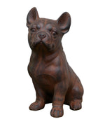 Brown dog statue on a wooden surface with a plant in the background