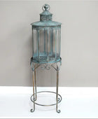 Decorative lantern with glass panels on a metal stand against a plain background
