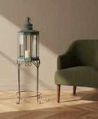 Green armchair in a room with a decorative lantern and plant