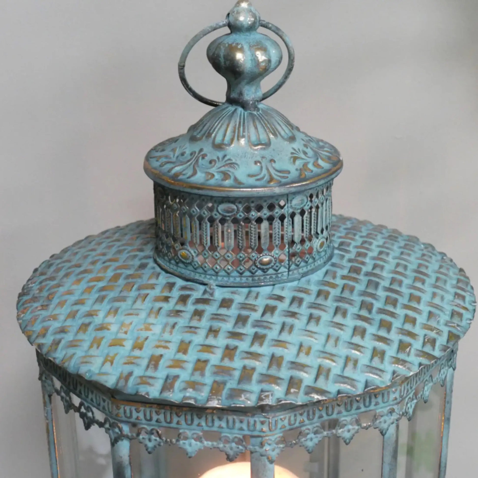 Decorative blue lantern with intricate design on a white background