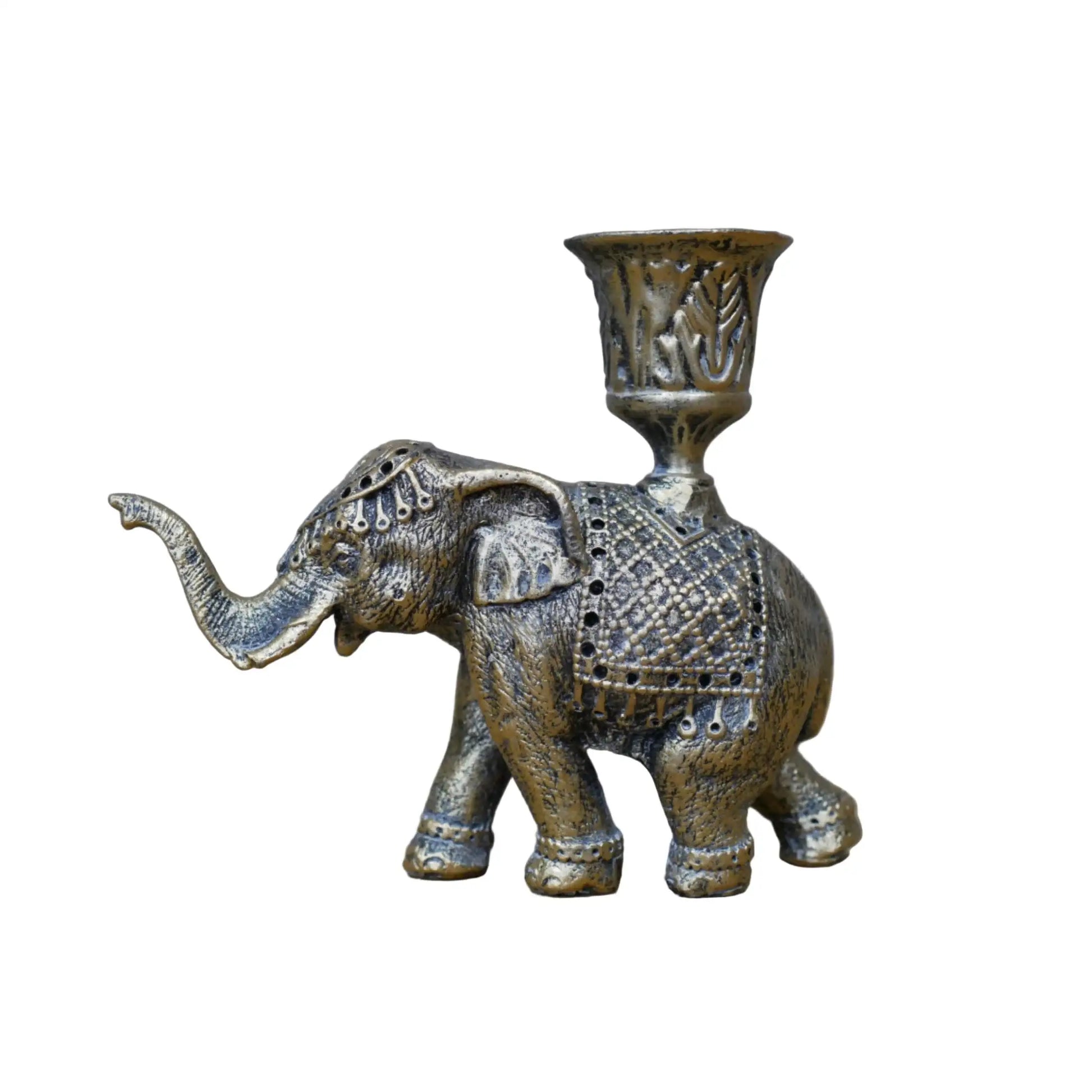 Decorative brass elephant candle holder on a wooden surface with a gray background