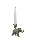 Decorative elephant candle holder with a lit candle on a wooden surface.