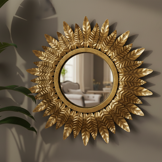 Decorative gold mirror with leaf-like design on a wall