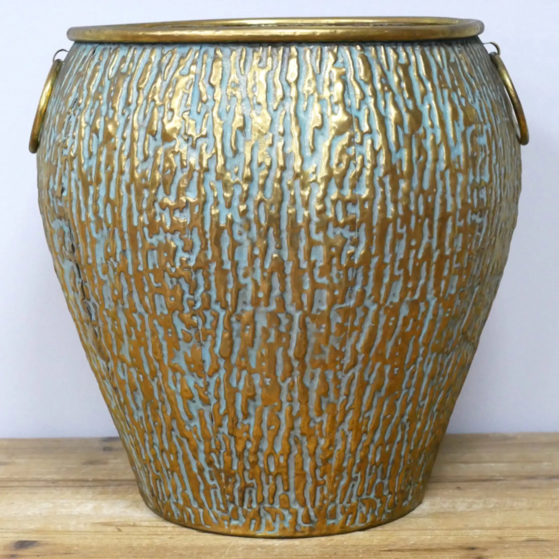 Decorative ceramic vase with textured surface on a wooden surface