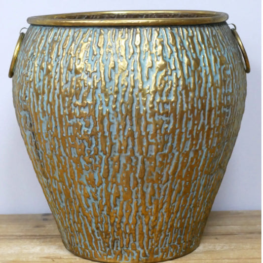 Decorative vase with textured surface and gold accents on a wooden surface.