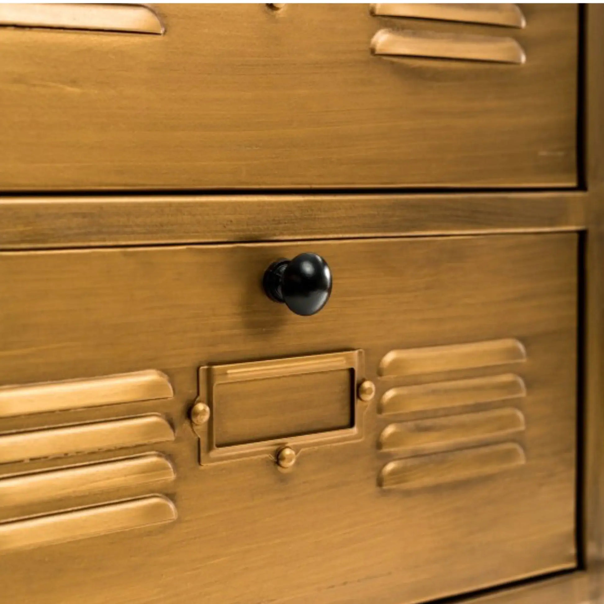 Close-up of a gold metal locker with a black handle