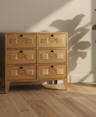 Wooden dresser with multiple drawers in a room with a plant and wooden floor.