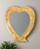 Heart-shaped mirror with gold decorative frame on a white background