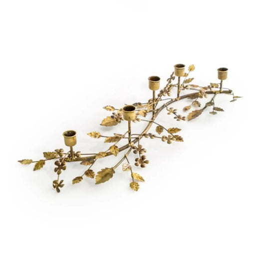 Decorative gold candle holder shaped like a leafy branch on a white background