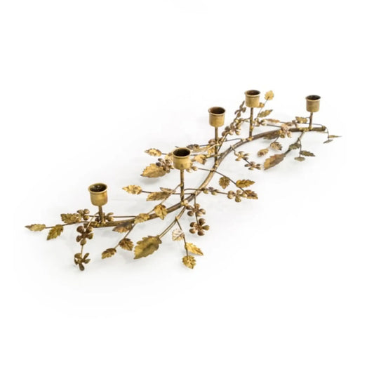 Decorative gold candle holder shaped like a leafy branch on a white background