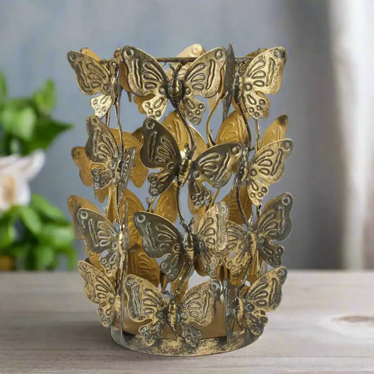 Decorative candle holder with butterfly designs on a white background