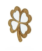 Gold four-leaf clover-shaped object on a white background