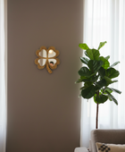 Decorative wall mirror with a plant and cushion on a sofa in a room.