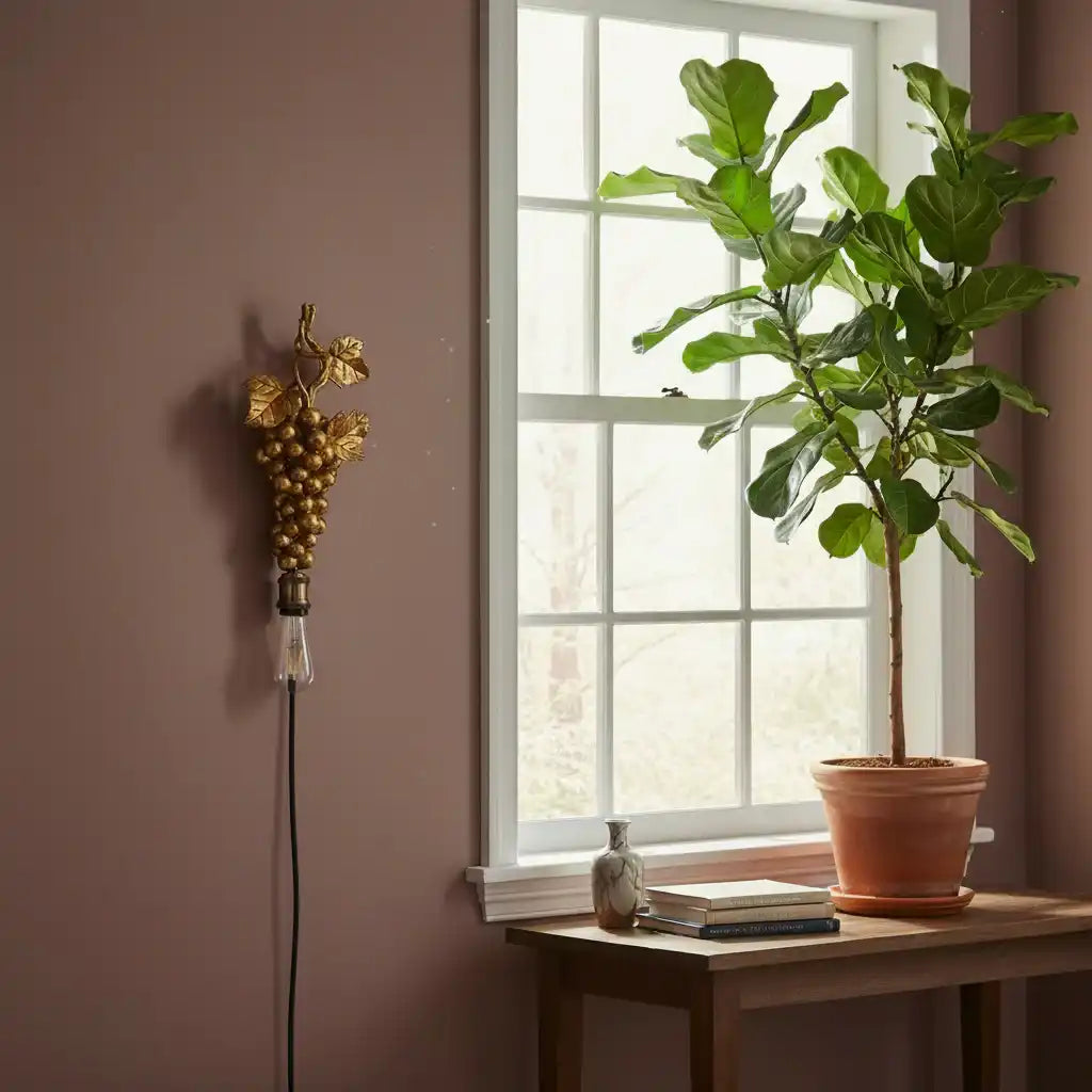 Potted plant on a windowsill with decorative light fixture on the wall.