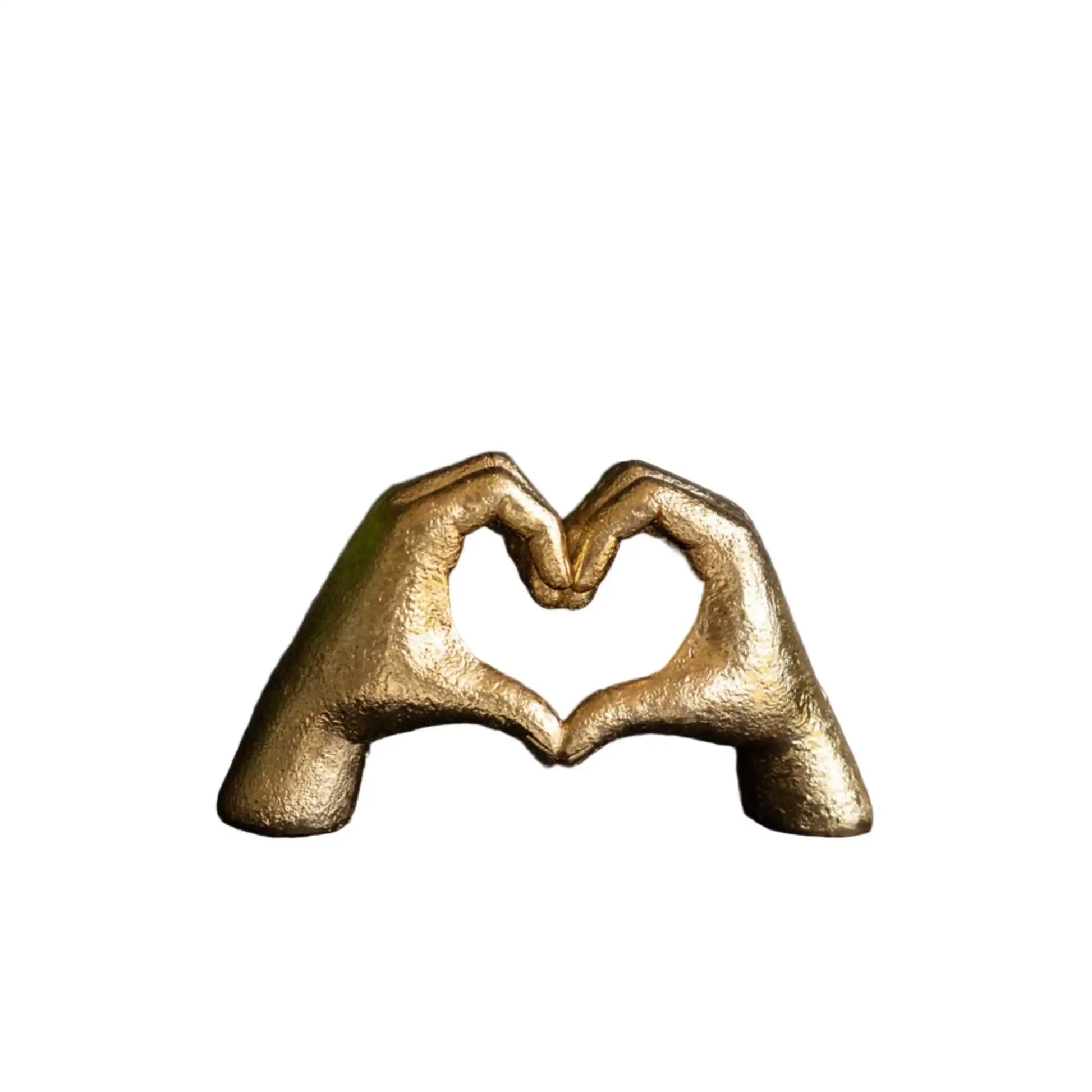 Bronze sculpture of two hands forming a heart shape on a white background