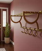 Decorative wall hook with hooks on a maroon wall next to a door.