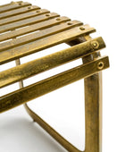 Close-up of a brass metal stool on a white background