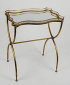 Decorative gold metal table with intricate design on a gray background