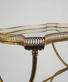 Gold metal table with intricate design on a gray background
