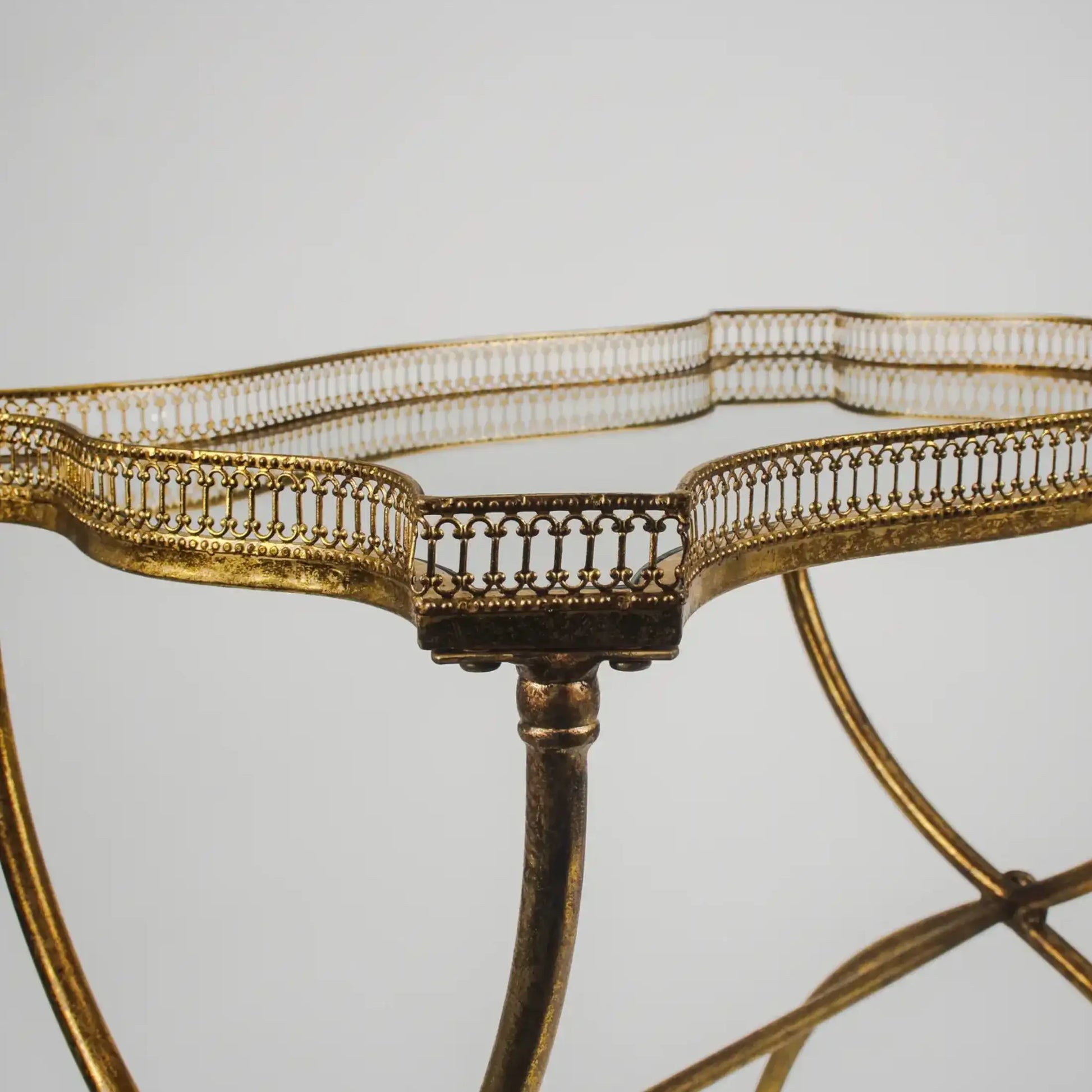 Gold metal table with intricate design on a gray background