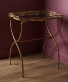Gold metal console table against a purple wall