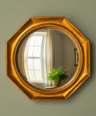 Gold octagonal mirror on a green wall