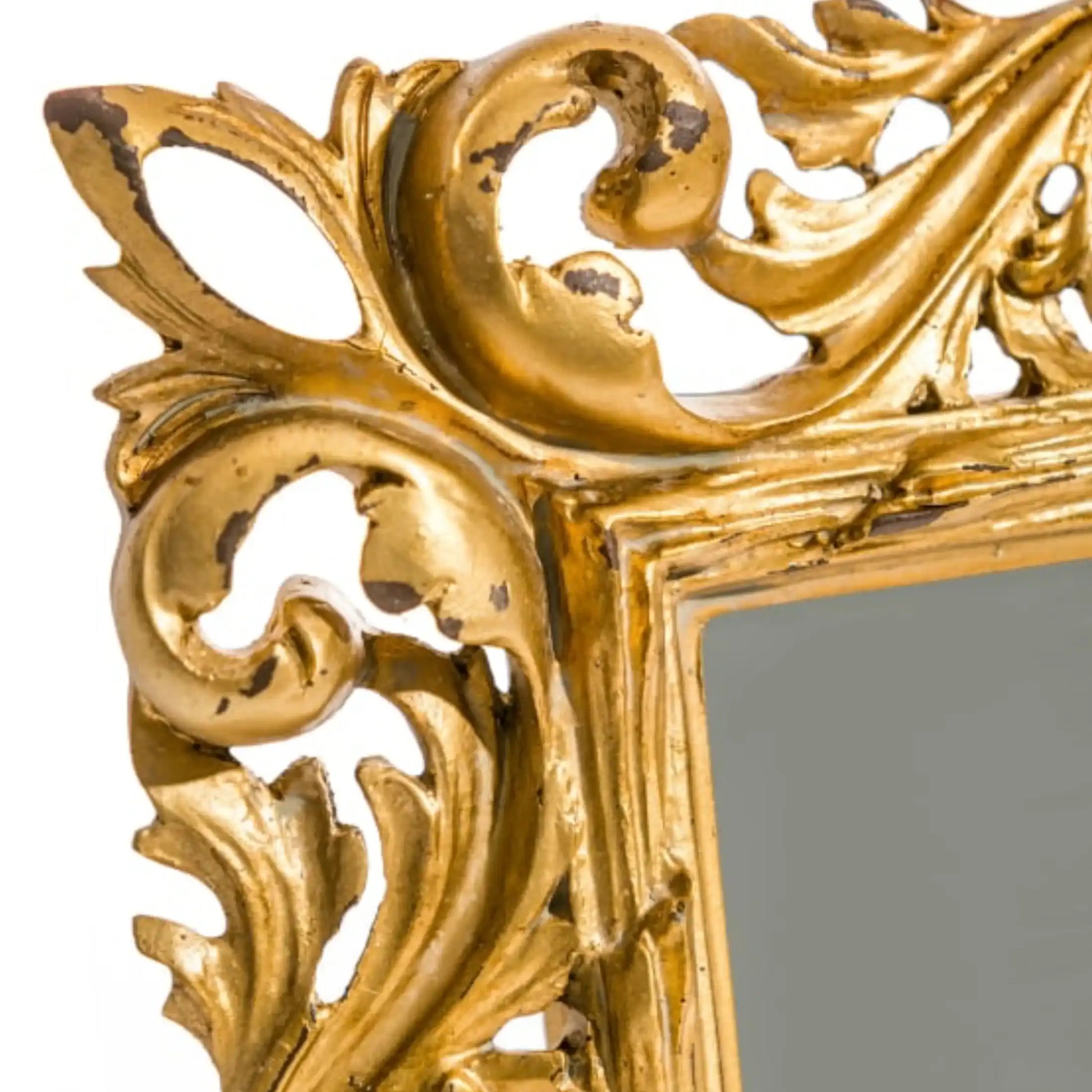 Close-up of an ornate gold mirror frame with intricate designs.