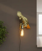 Decorative wall light fixture on a wall next to a plant and window.