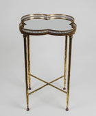 Decorative side table with gold metal frame and glass top on a gray background