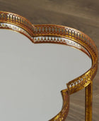 Gold-framed mirror on a wooden surface