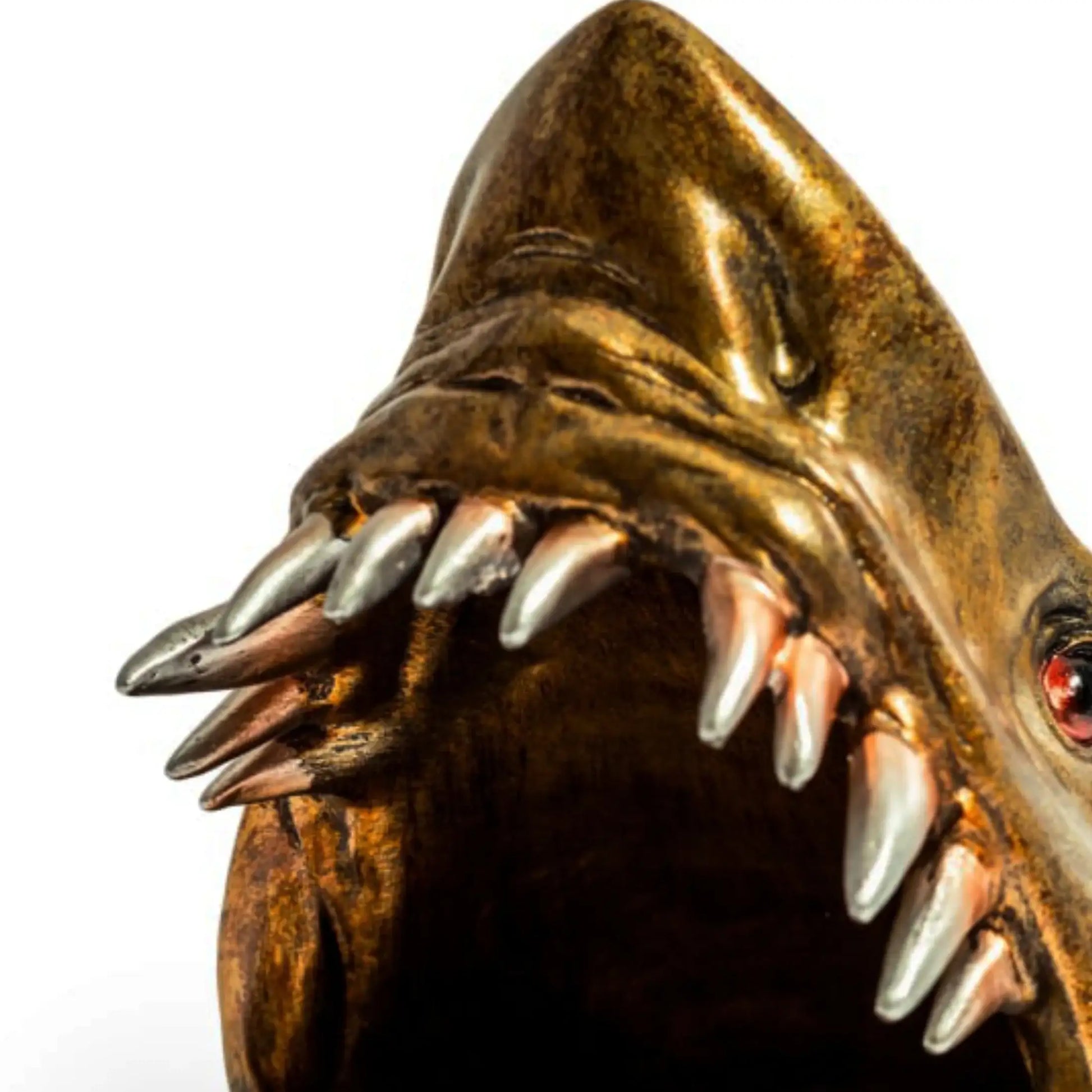 Bronze sculpture of a creature with sharp teeth on a white background