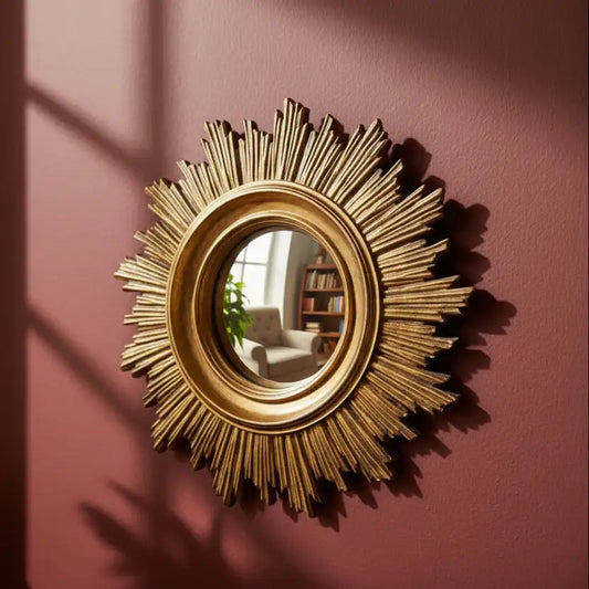 Gold sunburst mirror on a pink wall