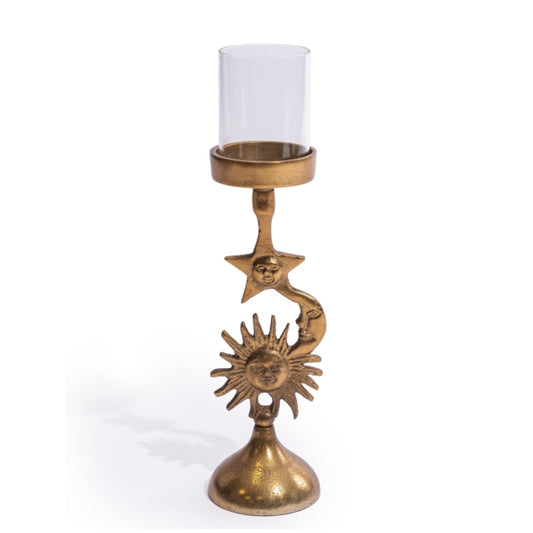 A decorative brass candle holder with a clear glass candle sleeve, featuring celestial sun and moon faces on a white background.