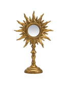 Decorative gold sun-shaped mirror on a white background