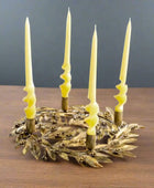 Decorative candle holder with four lit candles on a white background