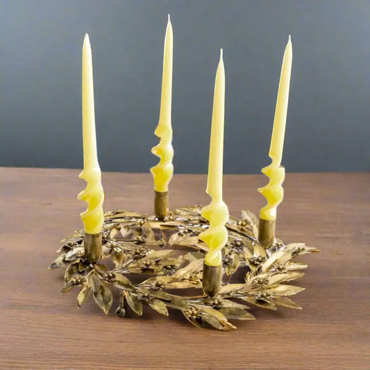 Decorative candle holder with four lit candles on a white background