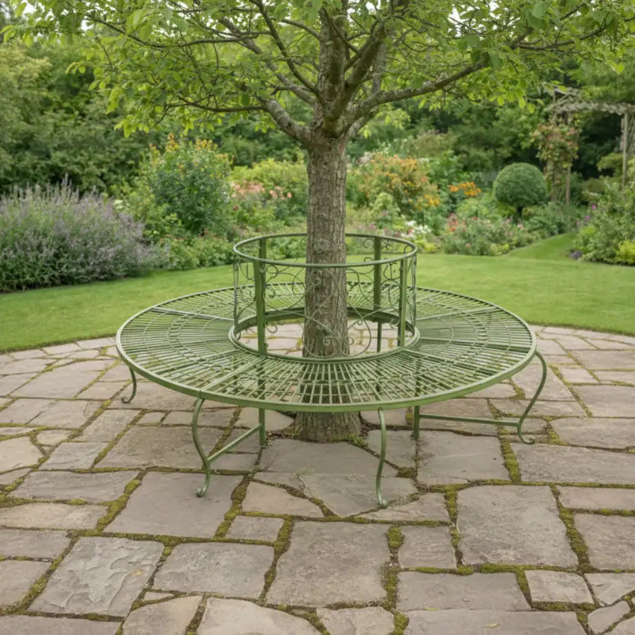 Round metal garden seat wrapped around a tree in a lush garden setting