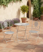 Outdoor patio set with metal table and chairs on a tiled patio.