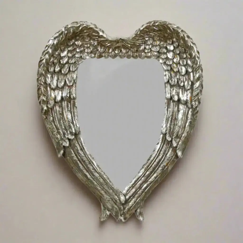 Heart-shaped mirror with angel wings on a white background