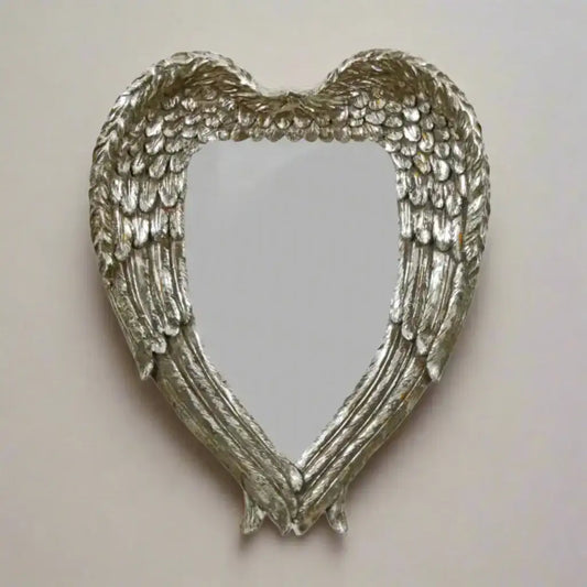 Heart-shaped mirror with angel wings on a white background