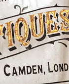 Vintage-style sign with 'Antiques' and 'Camden, London' text on a white background