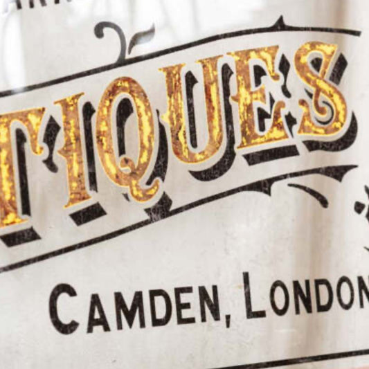 Vintage-style sign with 'Antiques' and 'Camden, London' text on a white background