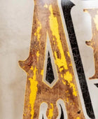 Close-up of a distressed metal sign with 'A' and 'N' letters.