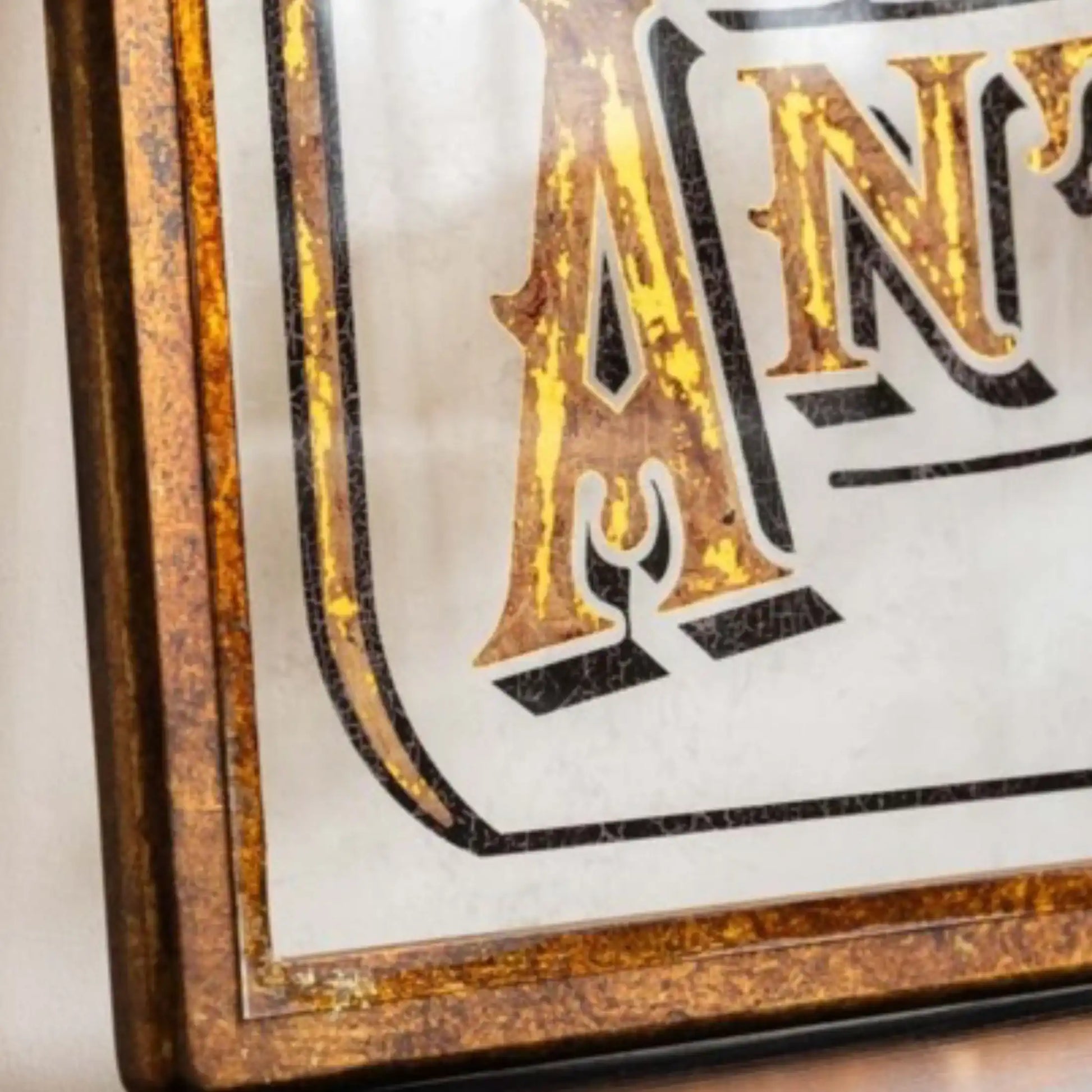 Decorative sign with 'AN' in a decorative frame on a white background