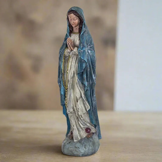 Statue of a religious figure in a blue robe on a white background